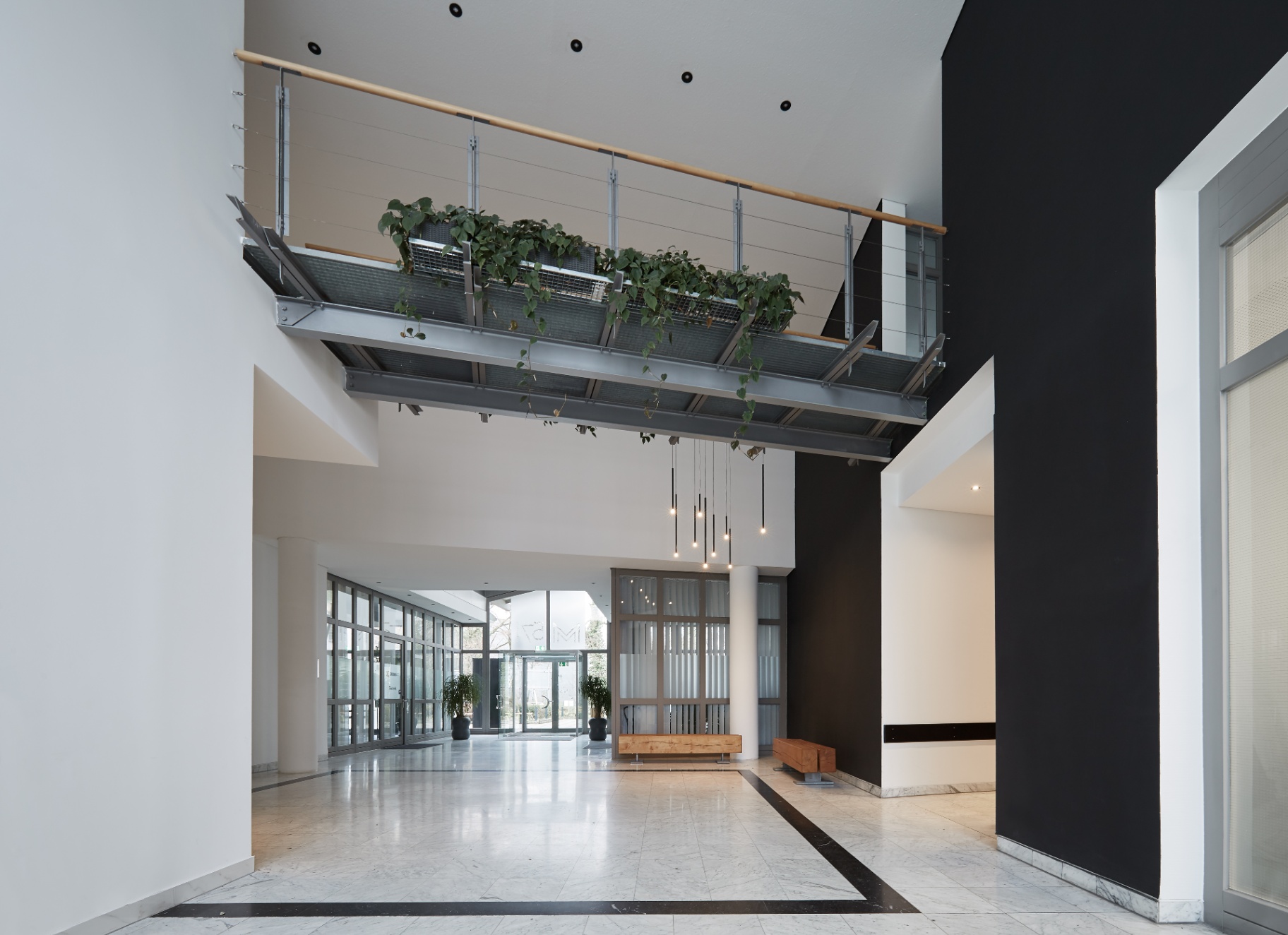 Doppelgeschossiges Foyer mit begrünter Galerie und Lichtinstallation